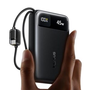 Eine Person hält eine schwarze Baseus Powerbank. Die Powerbank hat ein CCC Logo auf der Seite und ist an einem Ladekabel angeschlossen. Das Display der Powerbank zeigt an, dass sie derzeit lädt.